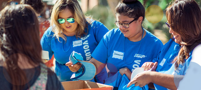 SRP employees sorting donated items outside into boxes.