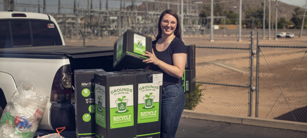 Woman is stacking recycling boxes next to a truck