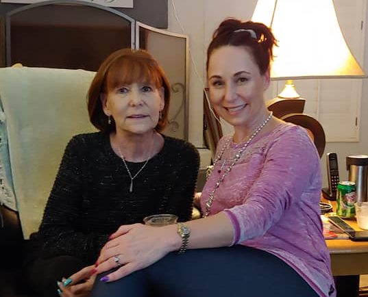 Image shows a mother and daughter sitting together.